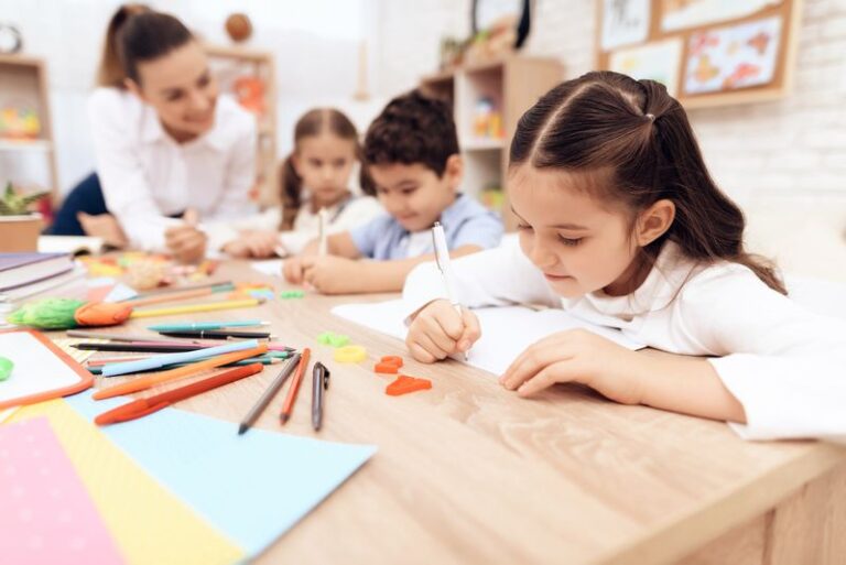Children write in notebooks with a pen